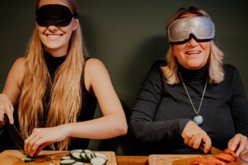 Bord med deltagere, der morer sig med Blingo under en Dinner in the Dark teambuilding, hvor samarbejde og kommunikation udfordres i mørke omgivelser