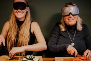 Bord med deltagere, der morer sig med Blingo under en Dinner in the Dark teambuilding, hvor samarbejde og kommunikation udfordres i mørke omgivelser